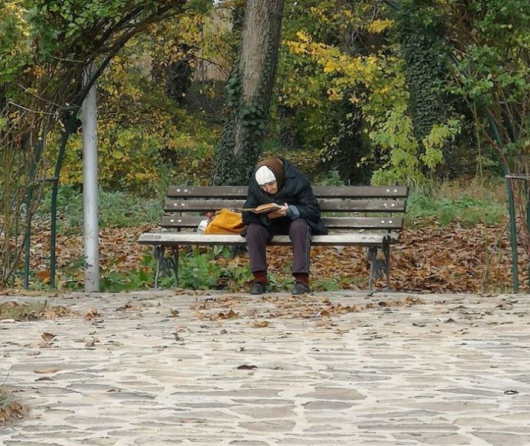 Възрастна жена на пейка и с книга в ръка Наистина