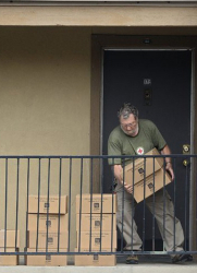 Служител на Червения кръст изнася храна и вещи от апартамента, където е пребивавал първият диагностициран с Ебола в САЩ. Сн.: EPA/БГНЕС