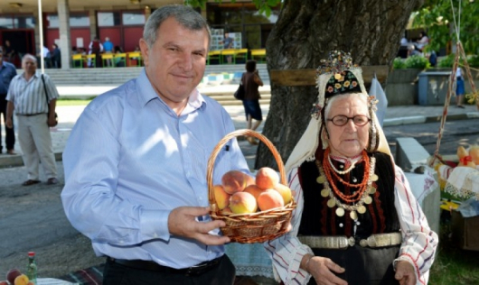 Министър Греков се радва на праскови - родно производство. Снимка: БТА