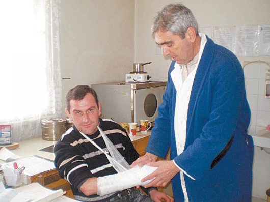 Д-р Сотир Каралийски гипсира ръката на поредната жертва на ледената пързалка в Дупница Георги Щрапульов
