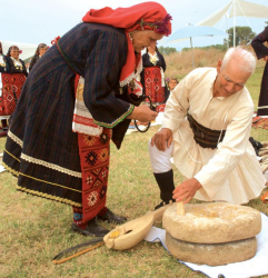 Участници от с. Яково на Старовремския събор в с. Спатово показват мелене на „бунгур” с камъни