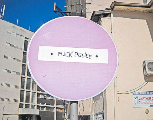 Пребоядисаният в розово фон на знака “Забранено влизането” с циничен надпис в бялата лента по адрес на полицията