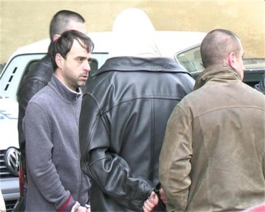 Съдията Юрий Маринов (вляво) изглеждаше спокоен при задържането му на 13 октомври 2009 г. пред дома му на кюстендилската ул. “Раковски”. Ченгето Чавдар Бурназки (с черното яке в гръб) си беше сложил качулка на главата и се криеше от репортерите.