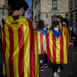 Протестираши в Барселона са провесили върху себе си знамето на независимостта на Каталуния. Сн.: БТА
