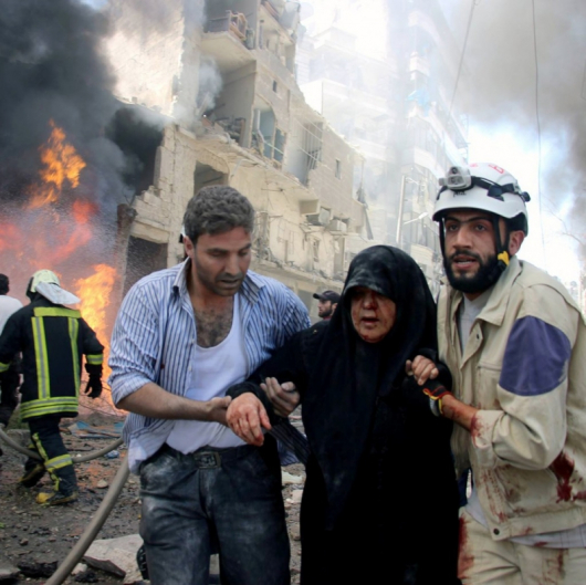 Спасители отвеждат ранена жена в Алепо. Сн.: БТА