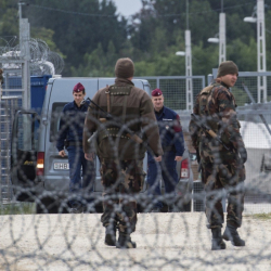 Гранични полицаи в Унгария до ограда, вдигната поради мигрантския наплив. Сн.: БТА