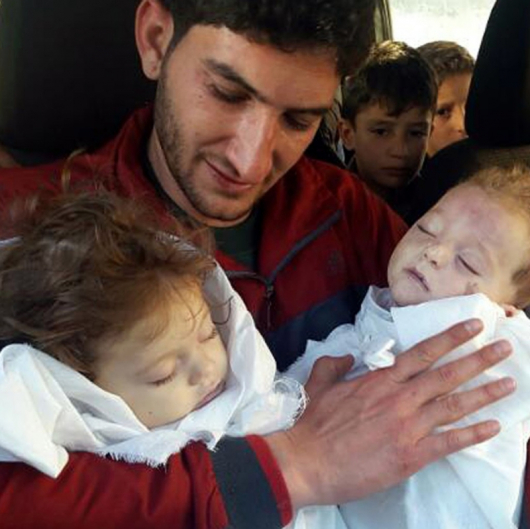 Мъж държи двете си загинали близначета след химическата атака в Идлиб. Сн.: БТА