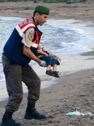 Полицай носи телцето на детето набежанци, изхвърлено на брега. Сн.: twitter