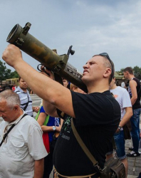 Мъж държи оръжие, иззето от бойците в Източна Украйна и разположено в Украинския държавен музей в Киев. Сн.: EPA/БГНЕС